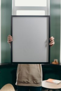 Image d'une personne tenant un cadre vide, utilisé pour spécifier l'absence d'une photo de profil